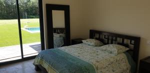 een slaapkamer met een bed en een deur naar een tuin bij La lavandière in Fox-Amphoux