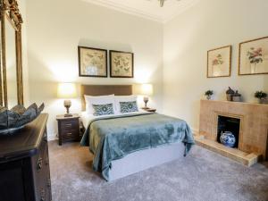 a bedroom with a bed and a fireplace at Gate Lodge - Threave Estate in Castle Douglas