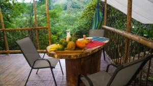 a bowl of fruit on a table on a porch at Glamping Salento y Posada Villa Alegría in Salento