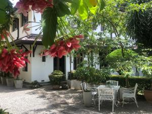 a patio with tables and chairs in front of a building at The Manor 1926 in Colombo