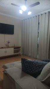 ein Wohnzimmer mit einem Sofa und einem Flachbild-TV in der Unterkunft Morada do Sol de Iguaba AP 2 qts in Iguaba Grande