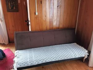 a brown couch in a room with a door at Casa en sector isla teja in Valdivia
