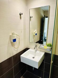 a bathroom with a white sink and a mirror at Swing & Pillows - Corona Inn Bukit Bintang in Kuala Lumpur