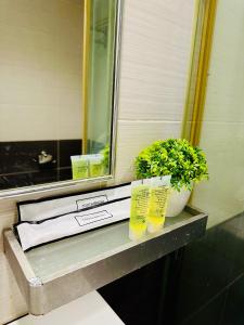 a table with a plant and two glasses on it at Swing & Pillows - Corona Inn Bukit Bintang in Kuala Lumpur