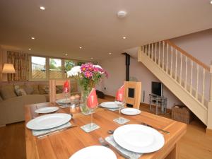 une salle à manger dotée d'une table avec des assiettes et des fleurs dans l'établissement 2 Bed in Bristol 72582, à Winford