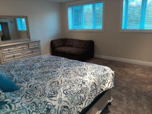 ein Schlafzimmer mit einem Bett, einem Sofa und Fenstern in der Unterkunft King guest apartment in Ottawa