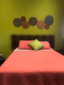 1 dormitorio con 1 cama con sábanas rojas y platos en la pared en Noelle’s House - Alto Boquete, a natural place to enjoy., en Alto Boquete