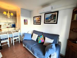uma sala de estar com um sofá azul e uma cozinha em Apartamento Roses, 1 dormitorio, 4 personas - ES-258-117 em Roses