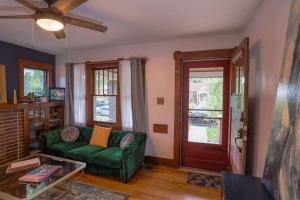 a living room with a green couch and a door at Excellent Location Mins from Dining & DT! in Denver