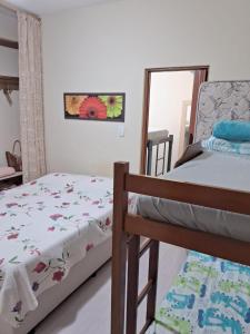 a bedroom with two beds and a mirror at Casa de praia de Ibicuí - RJ in Mangaratiba