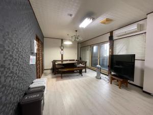 ein Wohnzimmer mit einem Billardtisch und einem TV in der Unterkunft 新潟県小千谷市 平成イン 
