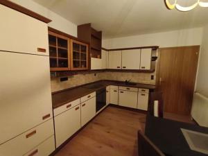 an empty kitchen with white cabinets and wooden floors at Schöne Ferienwohnung am Land 