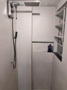 a shower in a white bathroom with a shower at Magnífico apartamento in Rio de Janeiro