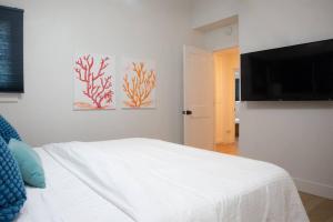 1 dormitorio con 1 cama y TV de pantalla plana en Geometric Loft: renovated, hip, pets, pool/spa, en Solana Beach