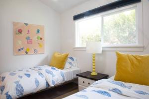 1 dormitorio con 2 camas y ventana en Geometric Loft: renovated, hip, pets, pool/spa, en Solana Beach