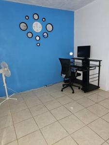 biuro z biurkiem i niebieską ścianą z zegarem w obiekcie Veronica's Tropical Oasis w Christiansted