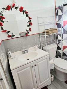 a bathroom with a sink and a toilet and a mirror at Veronica's Tropical Oasis in Christiansted