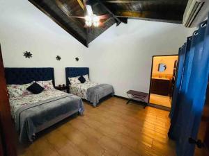 Habitación con 2 camas y espejo. en Las guacamayas House, en Copan Ruinas
