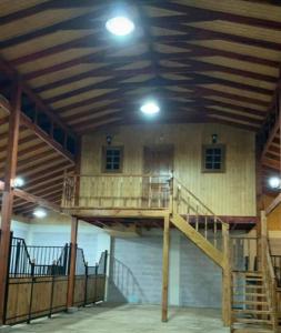 une grande chambre avec un escalier en bois dans un bâtiment dans l'établissement Rancho.JC, à Colbún