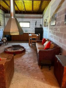 sala de estar con sofá y chimenea en Rancho.JC, en Colbún