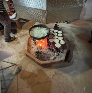 una olla de arroz y comida cocinándose sobre un fuego en Rancho.JC, en Colbún