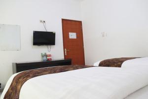 Кровать или кровати в номере Hotel Netral Jombang