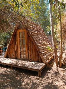 Casa con techo de paja y ventana en Bosques del Paico en El Monte