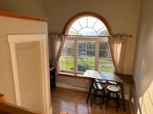 a dining room with a table and a large window at Tides Inn Guest Suites in Halls Harbour