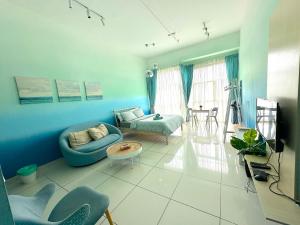 Sala de estar azul con sofá y mesa en 3 Towers Jalan Ampang By Serenity Vacation Homes, en Kuala Lumpur