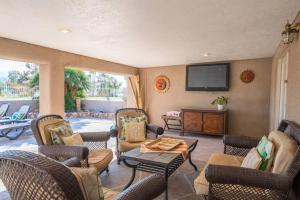 uma sala de estar com cadeiras e uma televisão de ecrã plano em City Bridge View , Spa, Pool ,Pet & Fam-Friendly em Lake Havasu City