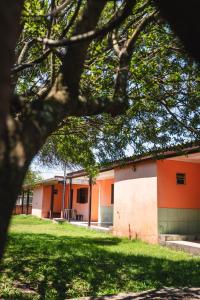 un bâtiment orange et blanc avec un arbre au premier plan dans l'établissement Pousada Salinas Valle, à Tramandaí