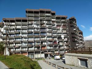 蒂涅的住宿－Studio Tignes, 1 pièce, 4 personnes - FR-1-502-554，一座大型建筑,前面有汽车停放