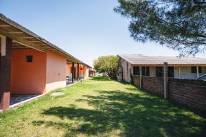 une cour vide à côté d'un bâtiment avec une clôture dans l'établissement Pousada Salinas Valle, à Tramandaí