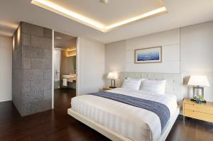 En eller flere senge i et værelse på Lotte Resort Jeju Artvillas