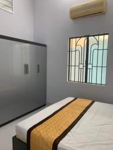 a bedroom with a bed and a window at The Grand Coco Homestay in Tây Ninh