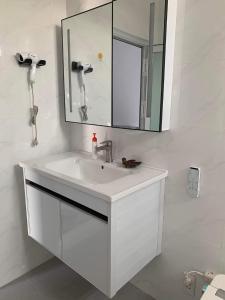 a white bathroom with a sink and a mirror at The Grand Coco Homestay in Tây Ninh +104 photos