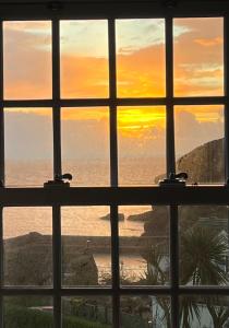 a view of the ocean through a window at 2a Coastguard Cottages in Gorran Haven