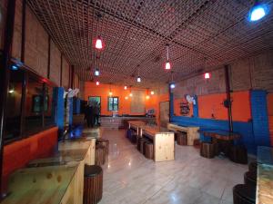 una habitación con mesas y bancos en un restaurante en Shivansh Inn Resort, en Rishīkesh
