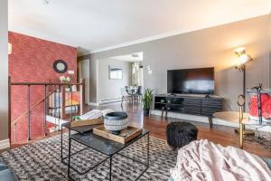 a living room with a large tv and a couch at Fancy 4BDR near DT free parking in Brossard