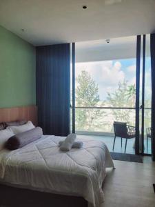 um quarto com uma cama grande e uma janela grande em RDHomeStay-RoxyBeachApt em Sematan