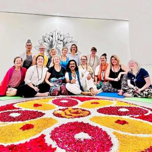 a group of people sitting in front of a flower rug at Shivansh Inn Resort in Rishīkesh