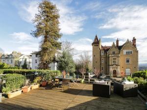 a garden with a table and chairs in front of a castle at The Hideaway in Great Malvern