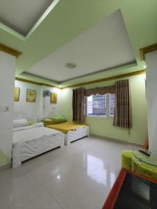 Habitación con 2 camas y ventana en VÂN HUỲNH HOTEL, en Da Lat