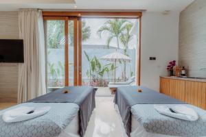 スミニャックにあるAstera Villa Seminyak by Ini Vie Hospitalityのバルコニー付きの客室内のベッド2台