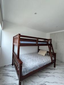 ein Etagenbett aus Holz in einem Zimmer in der Unterkunft Punta Centinela ( Cancún chiquito) in Punta Blanca
