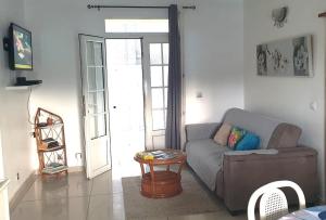 a living room with a couch and a table at Villa Bois Rose in Petit-Bourg
