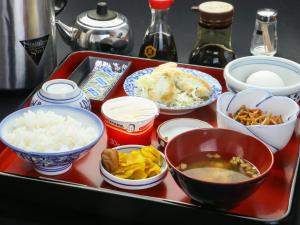 a red tray with various dishes of food on it at Yukikan in Yuki