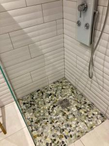 a shower with a floor covered in rocks at Savanna Sky in Fort-de-France