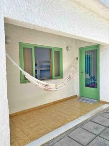 une chambre avec un hamac sur le côté du bâtiment dans l'établissement Casa Completa e Independente em Cabo Frio - RFV106, à Cabo Frio