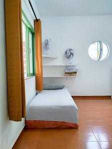 - un petit lit dans une chambre avec fenêtre dans l'établissement Casa Completa e Independente em Cabo Frio - RFV106, à Cabo Frio